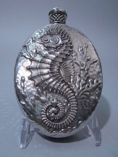 an ornate silver pocket watch with intricate designs