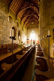 the interior of an old church with pews lined up in rows and stained glass windows