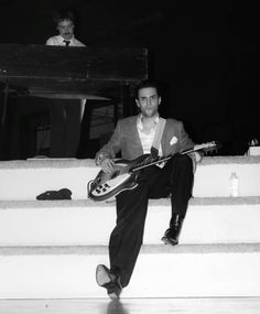 a man sitting on steps with a guitar in his hand