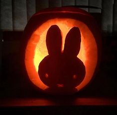 a carved pumpkin with an image of a bunny in the center and ears on it