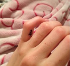 a person with a small tattoo on their finger