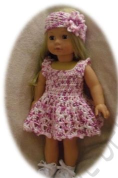 a doll wearing a pink crocheted dress and headband