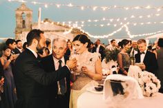 a bride and groom feeding each other cake at their wedding reception in front of an audience