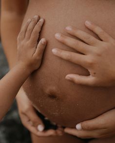 two hands on the belly of a pregnant woman