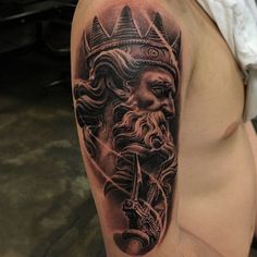 a man with a crown on his head is wearing a black and grey tattoo design