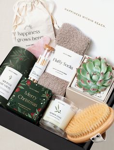 an open gift box containing candles, soaps, and other personal care items for the holiday season