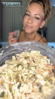 a woman sitting in front of a large bowl of food