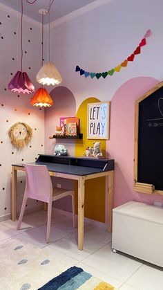 a child's playroom with pink walls and colorful lights hanging from the ceiling