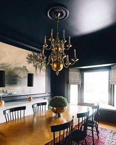 a dining room table with chairs and a chandelier hanging from it's ceiling