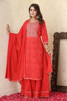 This is a 3-piece set. The set consists of bandhani print and embroidered kurta has round neck, 3/4th sleeves, calf length teamed with flared sharara and a dupatta. 3-piece set Color-Red Fabric-Cotton Kurta Length-Calf Length Sleeves-3/4th Sleeves Neck-Round Neck Work-Print & Embroidery Detailing Washing Care-Regular Wash or Machine Wash