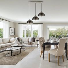 a living room filled with furniture and a dining table in front of a window next to a couch