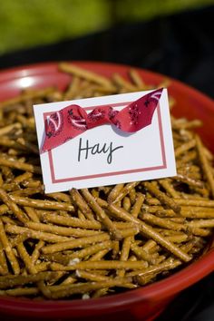 a red bowl filled with cheetos and a sign that says hay on it