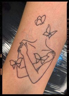 a woman's arm with a tattoo on it and butterflies flying above her head