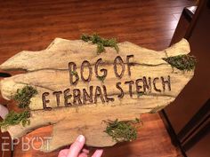 a wooden sign with moss on it that says bog of external - tech in the center