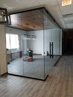 an empty office with glass walls and wooden floors