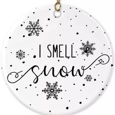 a white ceramic ornament with black and white snowflakes that says, i smell the snow