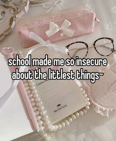 a pair of glasses sitting on top of a table next to a book and some pearls