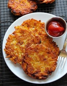 some food on a white plate with ketchup and sauces next to it