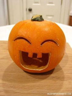 an orange pumpkin with its mouth open on a table