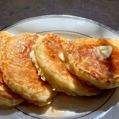 three pancakes on a plate with butter on top