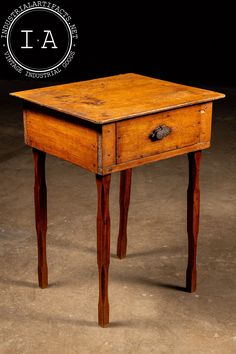 an old wooden table with one drawer open