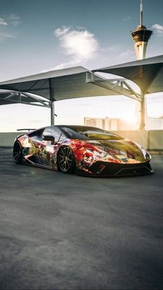 a very nice looking sports car parked in a parking lot with the sun shining on it