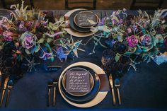 the table is set with purple and blue flowers