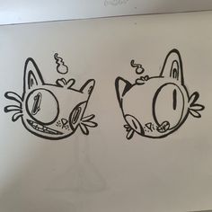 two drawings of cats with faces drawn on paper