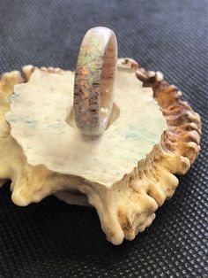 a wedding ring sitting on top of a piece of coral