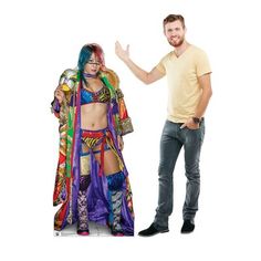 a man standing next to a woman dressed in colorful clothing and holding her hand out