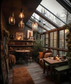 a room filled with lots of windows and furniture next to a wooden floor covered in plants