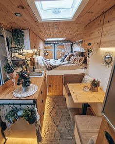 the interior of a small camper with wood paneling and white walls, windows, and wooden flooring