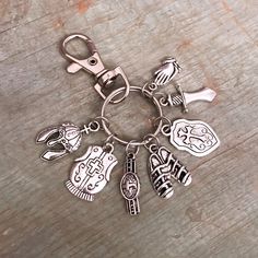 a metal keychain with various charms on it sitting on a wooden surface,