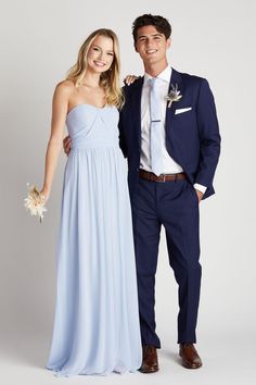 a man and woman in formal wear standing next to each other posing for the camera