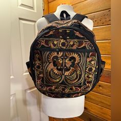 a backpack is hanging on a mannequin's head in front of a wooden wall