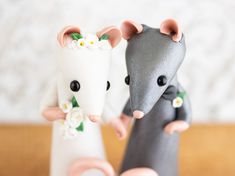 there are two figurines that look like mice holding each other's hands