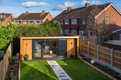 a small backyard area with grass and wooden fenced in areas around the yard, including a garden shed