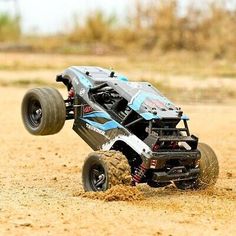 a toy truck that is in the dirt with it's front wheels up and out