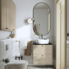 a bathroom with a toilet, sink and mirror in it's corner area on the wall