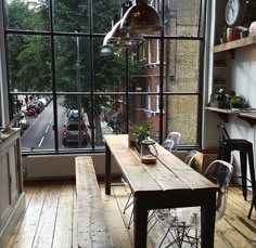 a table and chairs in front of a window with a view of the street outside