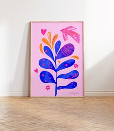 a pink and blue painting sitting on top of a wooden floor