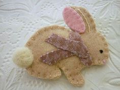 a small stuffed animal laying on top of a white tablecloth covered floor next to a lace doily