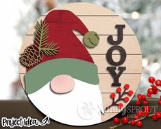 a wooden sign that says joy with a santa clause hat and pine cones on it