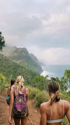 two women walking up a trail towards the ocean