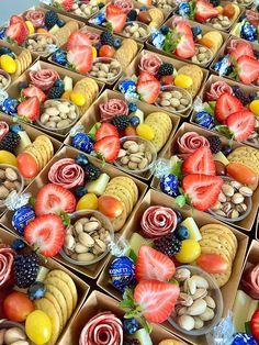 a table topped with lots of trays filled with fruit and veggie treats