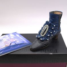 "Vintage Just the Right Shoe, by Raine  \" Victorian Ankle Boot\". Just the Right Shoe by Raine Beautiful Blue and black boot with pearl accents Released in Fall 1999  #25089 NO -COA  Original Box NO COA Measures  3 3/4 long x  2 1/2 inches high  Like New, Box in good Condition I have more of these collectible shoes on separate listings I have more of these collectible shoes on separate listings Some Not Listed yet THESE COME WITH COA AND BOXES La Rosa, Picnic Blue White, Picnic Red White, Countess, Posh I also have more not listed- DESTINY, ON FIRE, DEEPEST CUT, INTO THE BLUE, CARMEL KICK,DEVILISH, UNHINGED, AMETHYST ADVENTURE, ETERNITY THESE I HAVE WITHOUT BOXES AND NO COA Prisoner of Love, Snake Skin Wrap, Coral Kisses, Mother's Love, Spiked, Late foe a Date, Purple Dreams, Tantalizing Prisoner Of Love, White Picnic, Party Monster, Into The Blue, Doctor Who Tardis, Gold Digger, Monster Party, Shoe Gifts, Mothers Love