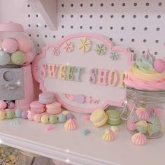 there is a pink sweet shop sign on the shelf next to other sweets and candies