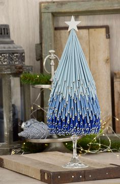 a blue and white christmas tree sitting on top of a wooden table next to other decorations