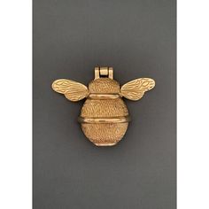 a gold bee brooch on a gray background