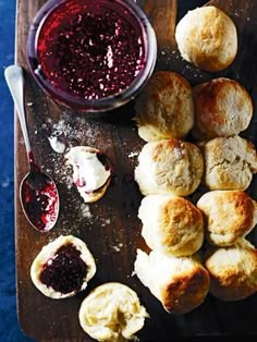 a wooden cutting board topped with biscuits and jam